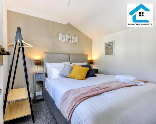 a bedroom with a large bed with yellow pillows at Great Location, Ideal Place for your December Stay, Close to the beach, station and restuarants, Cosy House l by Bluehouse Short Lets Brighton in Brighton & Hove