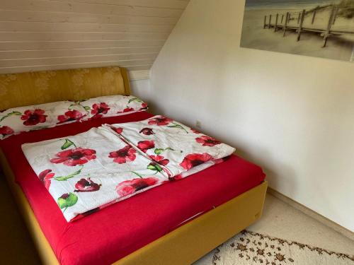 a bed with a red and white comforter on it at Wohnung nahe Jacobs Uni und Knoops Park in Bremen