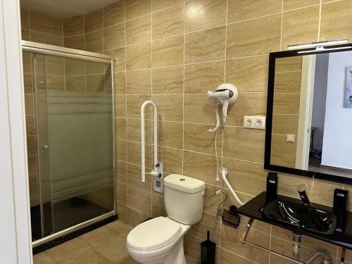 a bathroom with a toilet and a shower and a mirror at Vilador Beach Hotel in Masnou