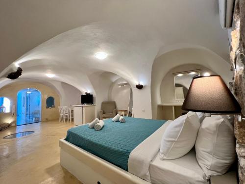 1 dormitorio con 1 cama en una habitación con techos abovedados en Traditional Cave Villa-Paradise & Prive Jacuzzi en Emporio