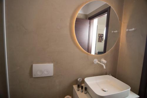 a bathroom with a white sink and a mirror at Spectacular apartment near Dance Hall/Center in Kalamata