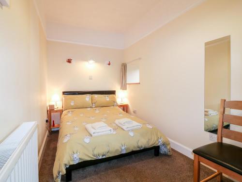 um quarto com uma cama com duas toalhas em Katmoget Cottage em Cupar