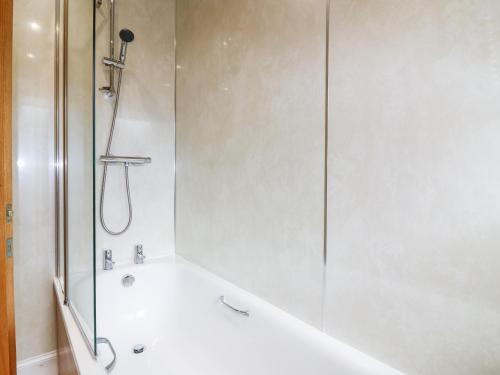 uma casa de banho com um chuveiro e uma banheira em Katmoget Cottage em Cupar