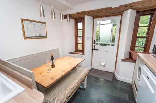 uma sala de jantar com uma mesa de madeira e uma porta em Barf Cottage em Portinscale
