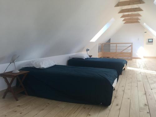two beds in a room with a staircase at La maison de Gwen in Cléden-Cap-Sizun