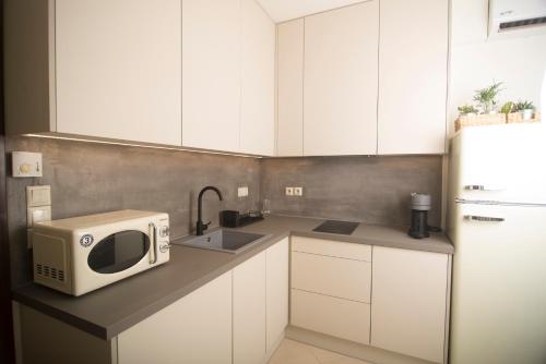 a kitchen with a microwave and a sink at Spectacular apartment near Dance Hall/Center in Kalamata