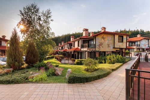 a group of houses in a town with a sidewalk at Ruskovets Thermal SPA & Ski Resort in Bansko