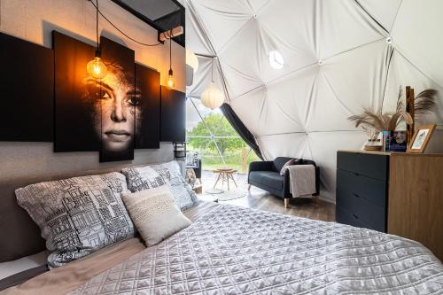a bedroom with a large bed with a poster of a man at GlampingSantoczno in Santoczno