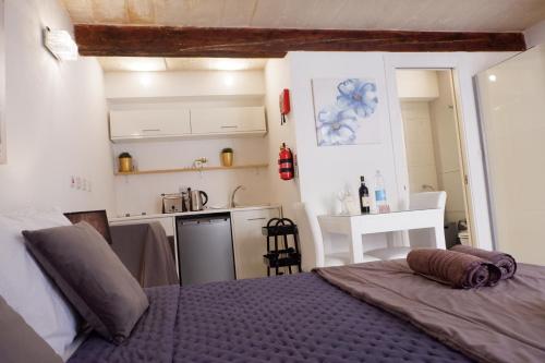 a bedroom with a bed and a small kitchen at SPQR Studios Valletta in Valletta
