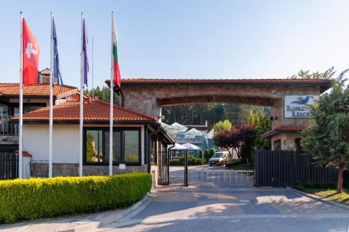 a building with flags in front of a building at Ruskovets Thermal SPA & Ski Resort in Bansko
