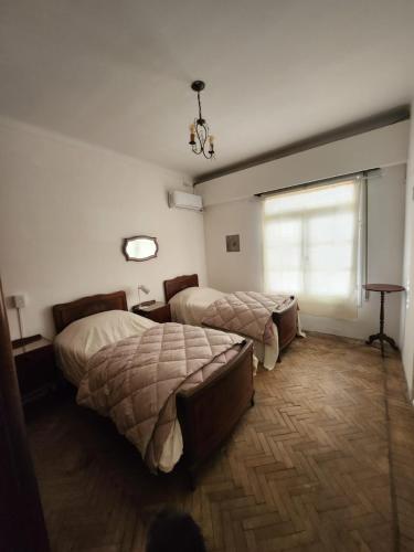 a bedroom with two beds and a window at Casa Amplia en Pleno Centro Histórico in Salta