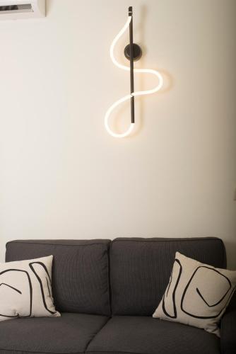a couch with two pillows and a light above it at Spectacular apartment near Dance Hall/Center in Kalamata