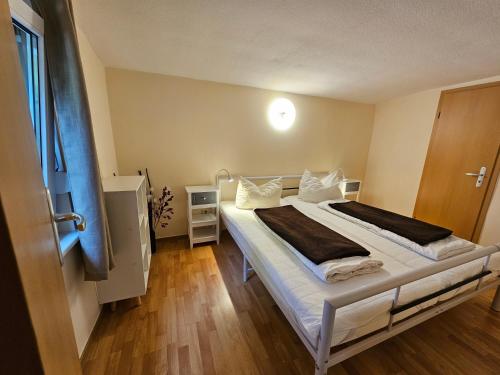 HertigswaldeにあるFerienhaus am Urzeitpark Sebnitzの白いシーツと窓のあるベッドのある寝室