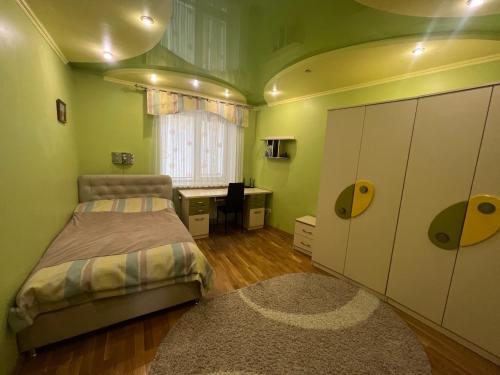 a bedroom with a bed and a desk in it at Bulvar in Ivano-Frankivsʼk