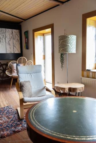 a living room with a table and a chair at Groeps-, Retreat- en Trainingsaccomodatie De Waterkroon! in Wieringerwaard