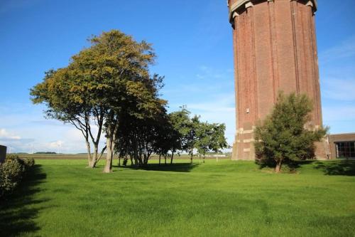 a large clock tower in the middle of a field at Groeps-, Retreat- en Trainingsaccomodatie De Waterkroon! in Wieringerwaard
