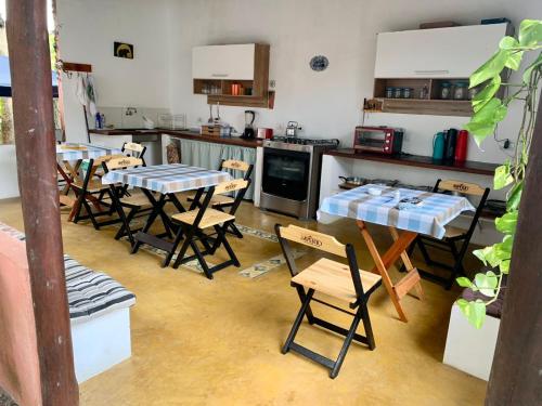 cocina con 4 mesas y sillas en Recanto Da Ursa, en Búzios