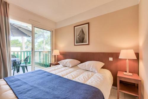 カルカンにあるResidence Les Grands Pins - maeva Homeのベッドルーム(ベッド1台付)、バルコニーが備わります。