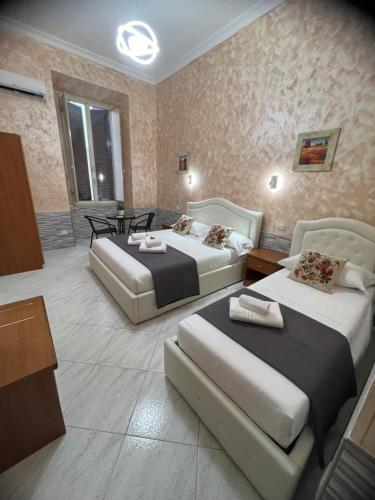 a hotel room with two beds and a table at Relax On 2 - Guesthouse in Rome