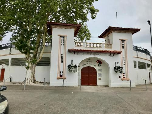 un bâtiment blanc avec un arbre devant lui dans l'établissement Bulle étoilée en Nature Landaise, à Saint-Sever