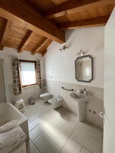 La salle de bains est pourvue d'un lavabo, de toilettes et d'un miroir. dans l'établissement B&B Il Melograno, à Monzambano