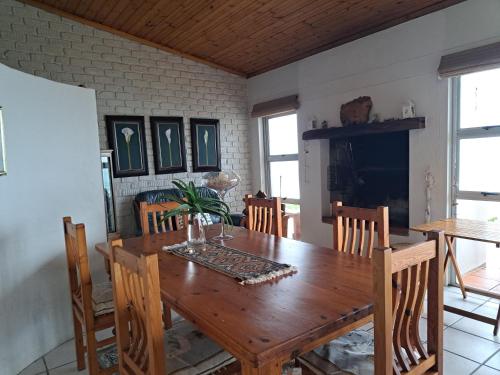 a dining room with a wooden table and chairs at Oceanview House in Struisbaai