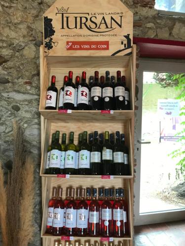 a bunch of bottles of wine on a shelf at Tente Nature 2 personnes in Saint-Sever