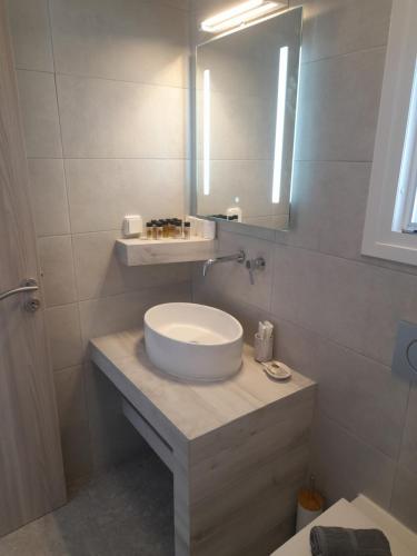 La salle de bains est pourvue d'un lavabo et d'un miroir. dans l'établissement Sand rooms Antiparos, à Andiparos