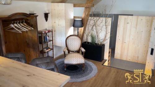 ein Wohnzimmer mit einem Stuhl und einem Tisch in der Unterkunft Chalet Münsterstadl in Altmünster