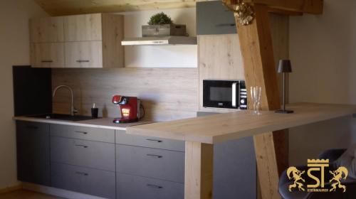 eine Küche mit einer Arbeitsplatte und einer Mikrowelle in der Unterkunft Chalet Münsterstadl in Altmünster