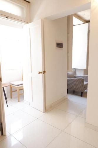 an open door in a room with white tile floors at SPQR Studios Valletta in Valletta
