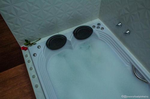 a bath tub with two black speakers in it at Pousada das Flores in Gonçalves