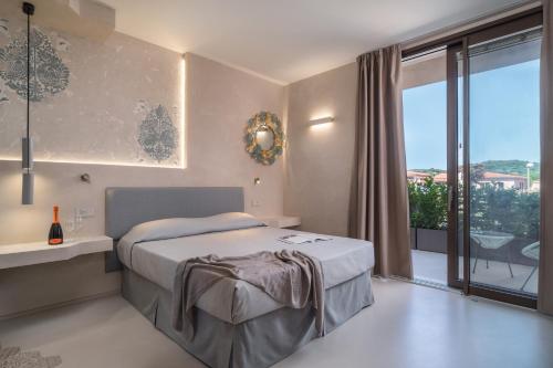 Villa Ilma Luxury Rooms في أرزاشنه: غرفة نوم بسرير ونافذة كبيرة