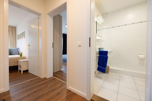 a bathroom with a tub and a sink in a room at Ferienwohnung WetterFest 11 in Wittdün