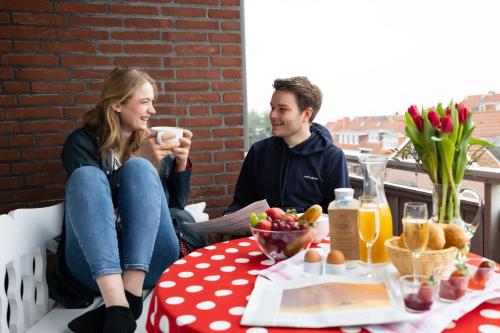 a man and a woman sitting at a table drinking coffee at Ferienwohnung WetterFest 11 in Wittdün