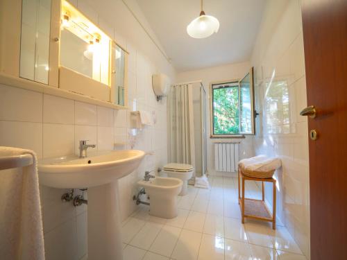 a white bathroom with a sink and a toilet at Residence Olimpo in Capo Vaticano