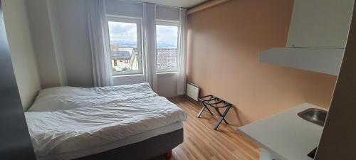 a small bedroom with a bed and a window at Systra Hotel Søvik in Syvik