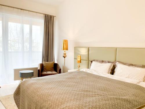 a bedroom with a large bed and a chair at Luxury suburb house - bright, quiet, beautiful in Vienna