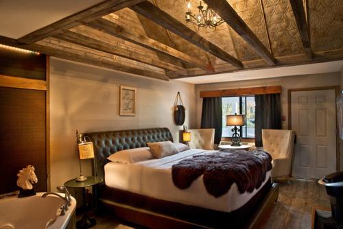 um quarto com uma cama grande e uma banheira em Maxwell Mansion Hotel em Lake Geneva