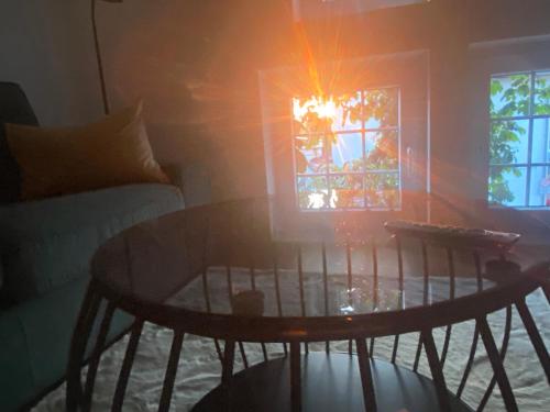 a table in a living room with the sun shining through a window at Scheunentraum Brenig in Bornheim