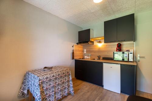 une petite cuisine avec une table dans une pièce dans l'établissement Les Anglines - Appt proche station de ski, aux Angles