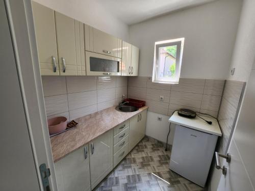 a small kitchen with white cabinets and a sink at Vila Kruna in Soko Banja