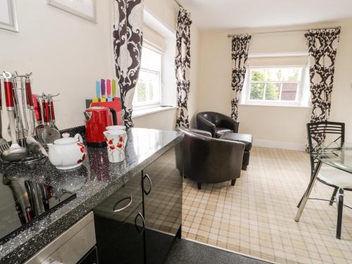 a kitchen with a black counter top and a chair at Lower Gardener's Cottage in Denbigh