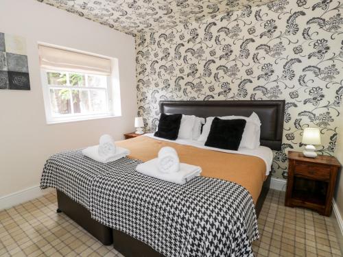 a bedroom with a bed with two towels on it at Lower Gardener's Cottage in Denbigh