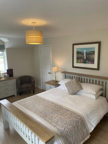 um quarto com uma cama grande e uma cadeira em Frongaer Bed And Breakfast em Llanerchymedd