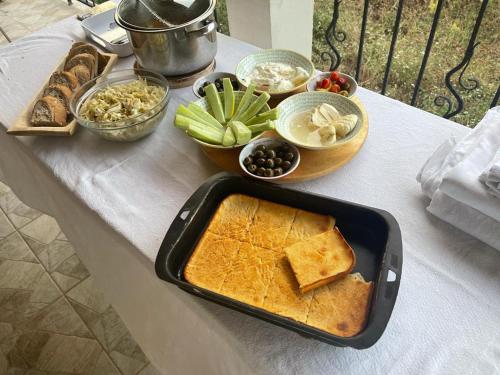 a table with a tray of bread and other foods at Guesthouse Tropojë e Vjeter in Tropojë