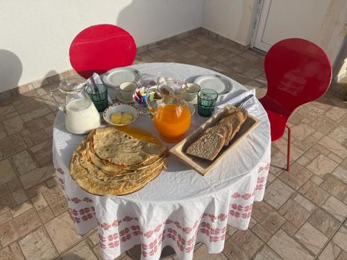 una mesa con un plato de comida, zumo de naranja y pan en Guesthouse Tropojë e Vjeter, en Tropojë