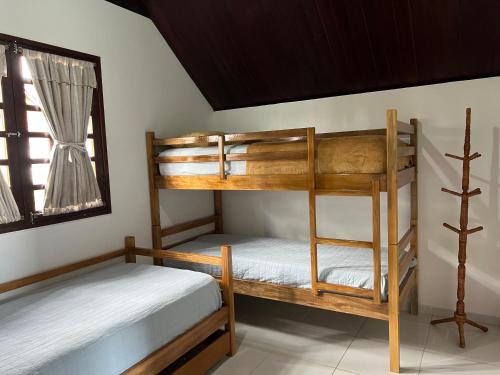two bunk beds in a room with a window at Chalé no Condomínio Serra Nevada I in Bananeiras