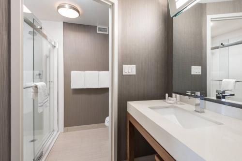 a bathroom with a white sink and a shower at Courtyard by Marriott Toronto Vaughan in Vaughan