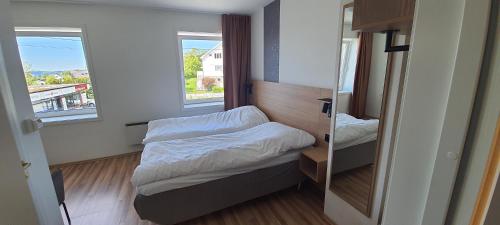 um pequeno quarto com uma cama e um espelho em Systra Hotel Søvik em Syvik